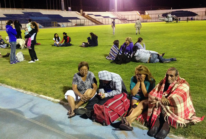 Locals take refuge at the city stadium following a tsunami alert after a powerful 8.0-magnitude earthquake hit off Chile's Pacific coast, on April 1, 2014 in Iquique. (AFP Photo / Aldo Solimano)
