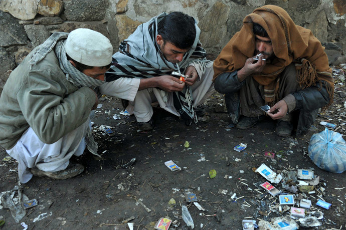 Afghan drug addicts smoke heroin on a street in Jalalabad on February 7, 2014. (AFP Photo / Noorullah Shirzada)
