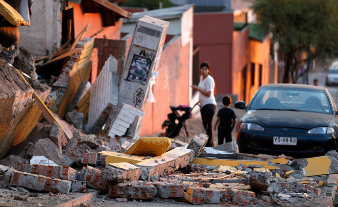 A resident looks at debris around a home after an earthquake and tsunami hit the northern port of Iquique April 2, 2014. (Reuters / Ivan Alvarado)