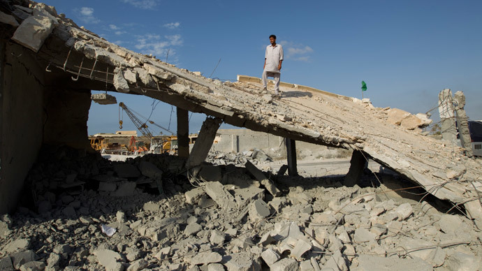 A man stands on the remnants of a school and mosque bombed by NATO forces according to Libyan officials in a village on the outskirts of Zlitan, 160km (99 miles) east of Tripoli, July 25, 2011.(Reuters / Caren Firouz)