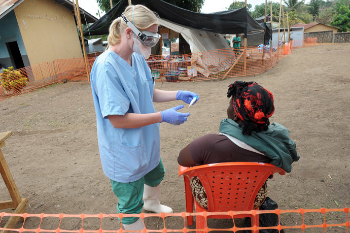A nurse of the 'Doctors without Borders' ('Medecin sans frontieres') medical aid organisation examines a patient in the in-take area at a center for victims of the Ebola virus in Guekedou, on April 1, 2014. (AFP Photo)