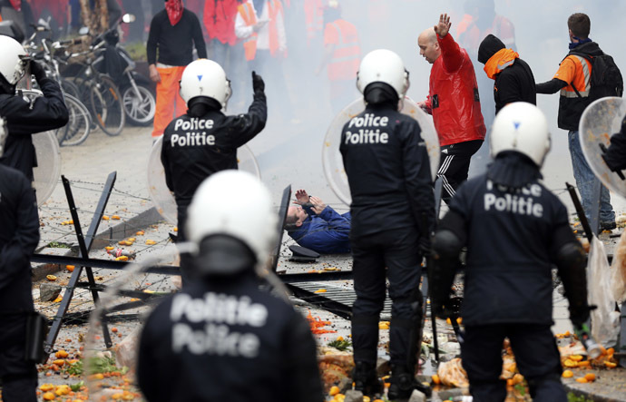 An injured demonstrator lies on the ground after being hit by a stone thrown by other demonstrators during a European trade unions protest against austerity measures, in central Brussels April 4, 2014. (Reuters/Francois Lenoir)