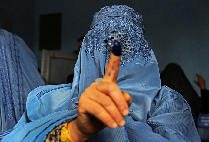 An Afghan woman shows her inked finger after voting at a polling station in the northwestern city of Herat on April 5, 2014. (AFP Photo / Aref Karimi)