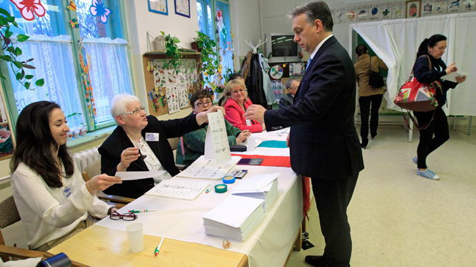 Hungary's Prime Minister Viktor Orban receives his ballot from an official during parliamentary elections in Budapest April 6, 2014 (Reuters / Bernadett Szabo)