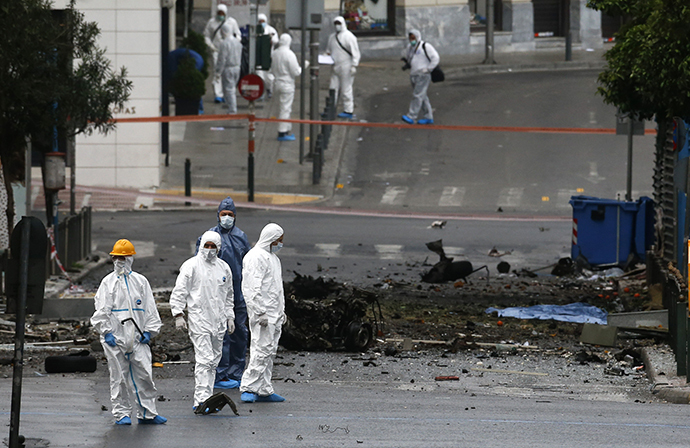 Forensic experts search for evidence on a street where a car bomb went off in Athens April 10, 2014. (Reuter / Alkis Konstantinidis)