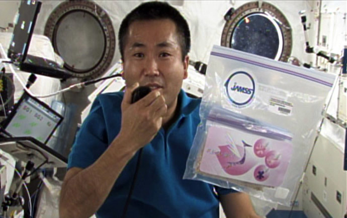Japanese astronaut Koichi Wakata holding a pack of cherry sheeds in the International Space Station on April 13, 2009 (AFP Photo / JAXA)