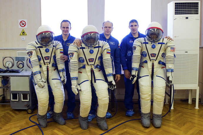 U.S. astronaut Michael Hopkins (R), Russian cosmonauts Oleg Kotov (C) and Sergey Ryazanskiy pose for a picture at the Baikonur cosmodrome, September 14, 2013. (Reuters/Sergei Remezov)