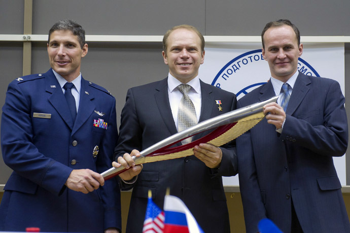 U.S. astronaut Michael Hopkins (L), Russian cosmonauts Oleg Kotov (C) and Sergey Ryazanskiy hold an Olympic torch at the Star City space centre outside Moscow, September 6, 2013. (Reuters/Sergei Remezov)