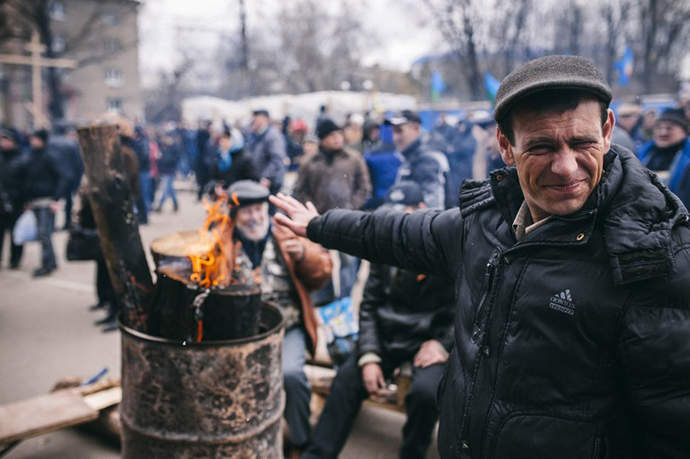 A pro-Russian activist squints as he warms himself near a fire outside the headquarters of Ukraine's security agency building in the eastern Ukrainian city of Lugansk on April 12, 2014. (AFP Photo / Dimitar Dilkoff)