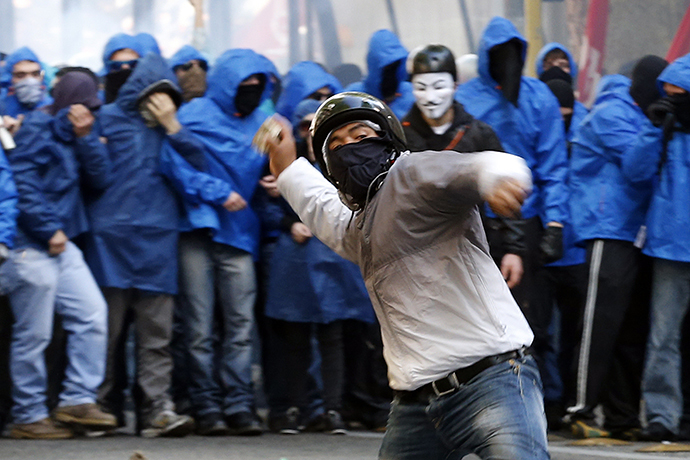A demonstrator throws a stone at policemen during a protest in downtown Rome April 12, 2014. (Reuters / Alessandro Bianchi)