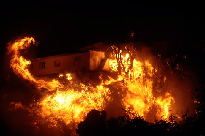 View of burning houses during a fire in Valparaiso, 110 km west of Santiago, Chile, on April 12, 2014. (AFP Photo/Felipe Gamboa)