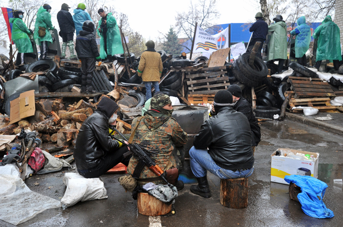 Pro-Russia activists warm themselves near a barricade outside a regional police building seized by armed separatists in Slavyansk on April 13, 2014 (AFP Photo / Genya Savilov)