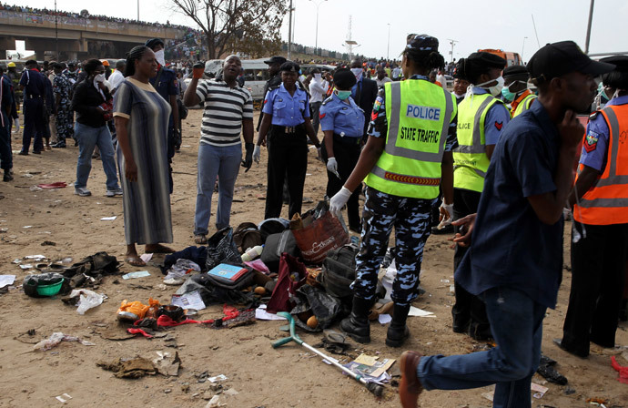 Police officers gather the belongings of victims at the scene of a bomb explosion at Nyanyan, in Abuja April 14, 2014. (Reuters / Afolabi Sotunde)