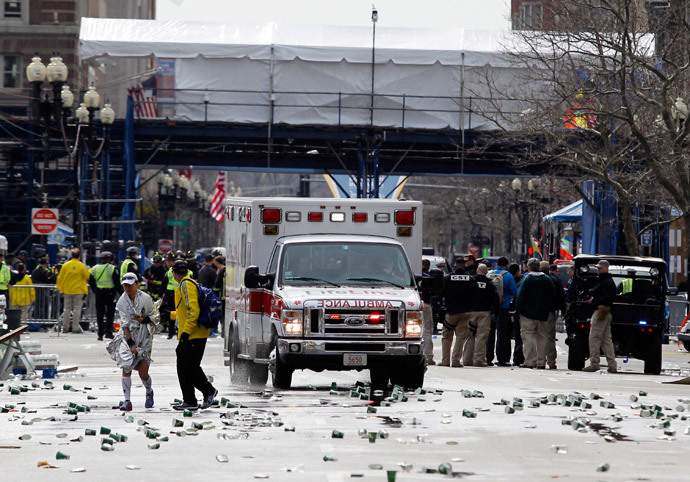 A runner is escorted from the scene after explosions went off at the 117th Boston Marathon in Boston, Massachusetts April 15, 2013. (Reuters / Jessica Rinaldi) 