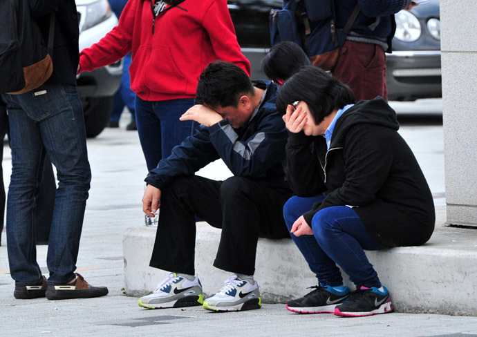 South Korean relatives of missing people react as they gather at a gym in Jindo on April 16, 2014 as rescue teams, including elite navy SEAL divers, raced to find up to 293 people missing from a capsized ferry carrying 459 passengers and crew -- mostly high school students bound for a holiday island. (AFP Photo)