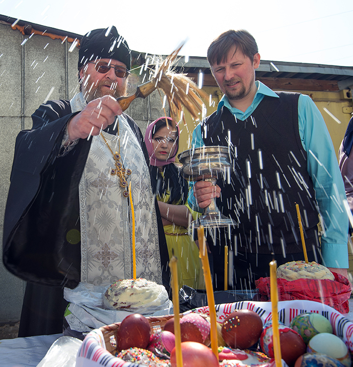 A Russian Orthodox priest blesses cakes and colored eggs during an Orthodox Easter ceremony in Moscow, on April 19, 2014, on the eve of the Orthodox Easter. (AFP Photo / Anatoly Tanin)
