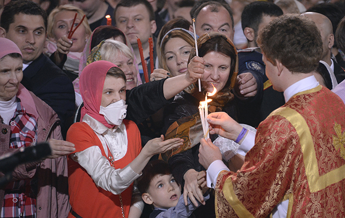 Believers receive the Holly Light during an Orthodox Easter service in Moscow, early on April 20, 2014. (AFP Photo / Alexander Nemenov)
