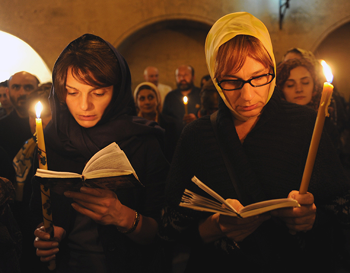 Georgian Orthodox believers attend a service as they celebrate an Orthodox Easter in a church in Tbilisi early on April 20, 2014. (AFP Photo / Vano Shlamov)
