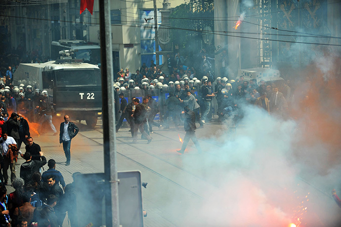 Galatasaray, Fenerbahce and Besiktas throw flares at the police as they protest against a new system of e-tickets on April 20, 2014, on Istiklal Avenue in Istanbul. (AFP Photo / Ozan Kose)