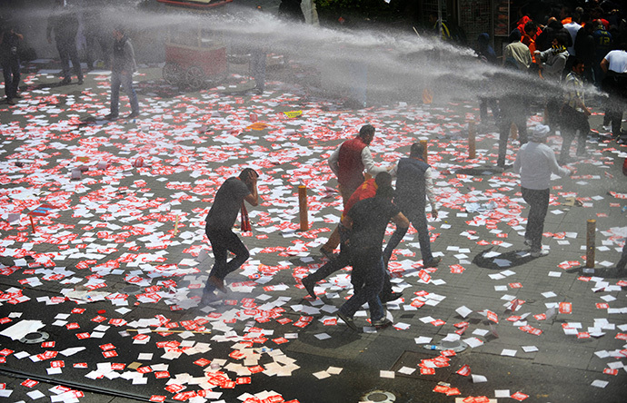 Police use water canons on Galatasaray, Fenerbahce and Besiktas supporters as they protest against a new system of e-tickets on April 20, 2014, on Istiklal Avenue in Istanbul. (AFP Photo / Ozan Kose)