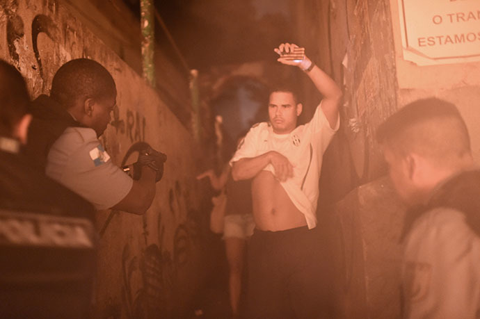 Brazilian Police Special Force members detain a man during a violent protest in a favela near Copacabana in Rio de Janeiro, Brazil on April 22, 2014. (AFP Photo / Christophe Simon)