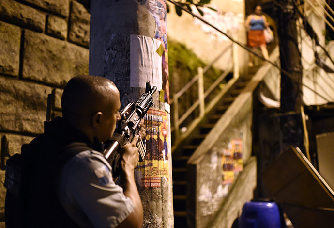 A Brazilian Police Special Forces member takes position during a violent protest in a favela near Copacabana in Rio de Janeiro, Brazil on April 22, 2014. (AFP Photo / Christophe Simon)