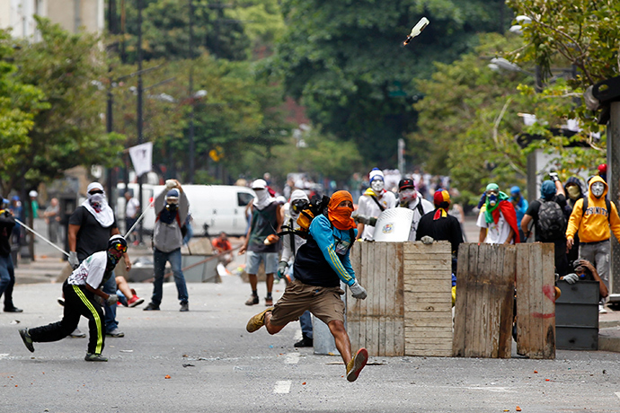 An anti-government protester throws a Molotov cocktail during riots with police in Caracas April 17, 2014 (Reuters / Christian Veron)