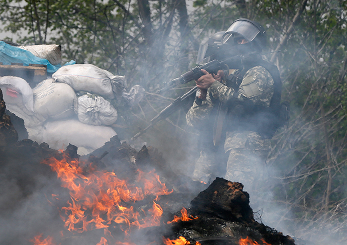 Ukrainian security force officers walk past a checkpoint set on fire and left by anti-goverment protesters near Slavyansk April 24, 2014 (AFP Photo / Gleb Garanich)