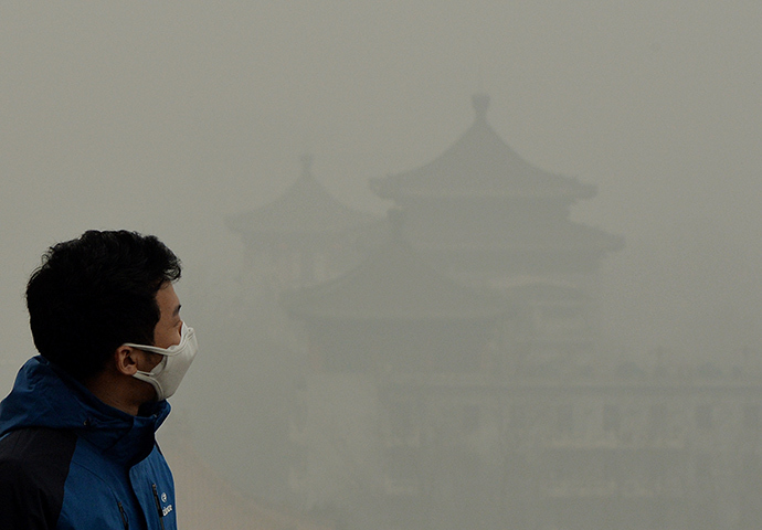 A tourist wearing a face mask climbs Jingshan Hill beside the Forbidden City as heavy air pollution continues to shroud Beijing (AFP Photo / Mark Ralston)