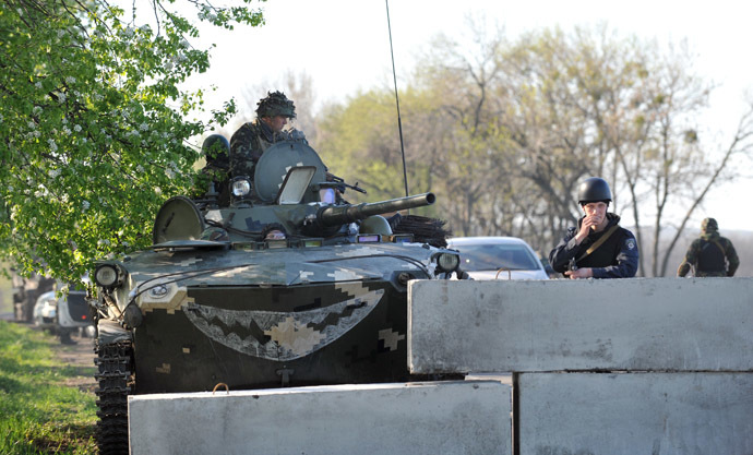 Ukrainian policeman and soldiers in a tank stand guard at their newly erected checkpoint near the eastern Ukrainain city of Slavyansk on April 25, 2014. (AFP Photo/Genya Savilov)