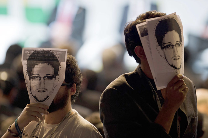 Demonstrators hold papers to be cut to make portraits of Edward Snowden in front of their own faces ai a protest during the opening ceremony during the opening ceremony of the "NETmundial â Global Multistakeholder Meeting on the Future of Internet Governance", on April 23, 2014 in Sao Paulo, Brazil. (AFP Photo/Nelson Almeida) 