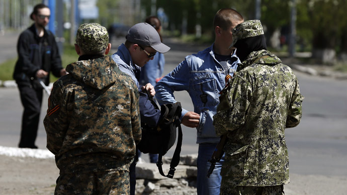 Two armed men (Front) check two men's identity papers in the eastern Ukrainian city of Slavyansk on April 26, 2014. (AFP Photo/Max Vetrov)
