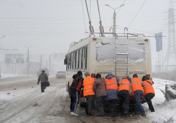 Municipal workers push a trolleybus during a heavy blizzard in Chelyabinsk, Russia (RIA Novosti/Aleksandr Kondratuk)