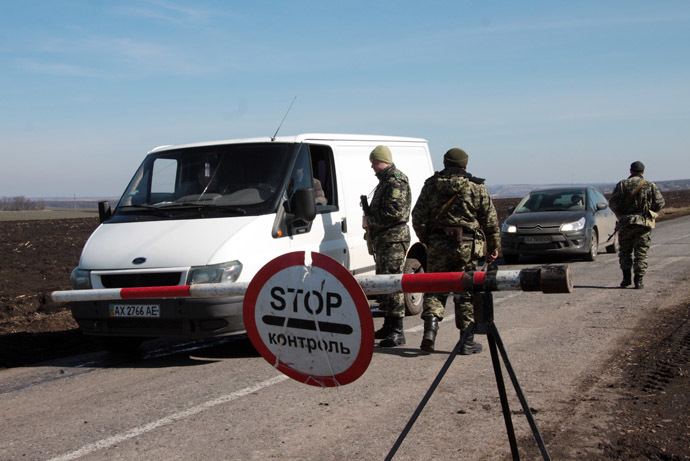 Ukrainian army soldiers check vehicles on a road not far from the border between Ukraine and Russia, in the Kharkiv region of eastern Ukraine (AFP Photo/Sergey Bobok)