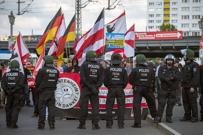 Activists from the far right party NPD are seen behind a police line at the start of their marches on the Jannowitz bridge in Berlin on April 26, 2014. (AFP Photo/Odd Andersen)