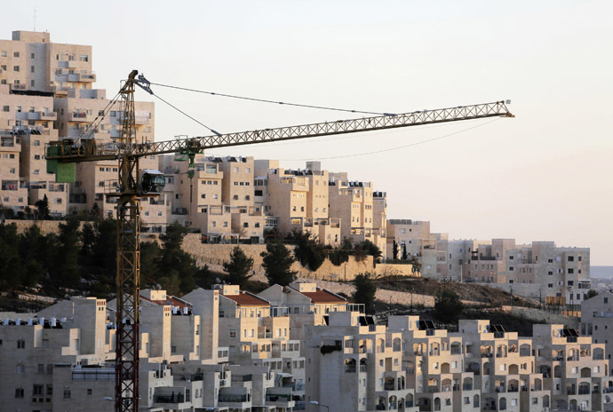 A crane is seen next to homes in a Jewish settlement near Jerusalem known to Israelis as Har Homa and to Palestinians as Jabal Abu Ghneim (Reuters)