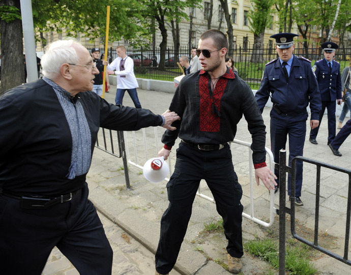 An man (L) argues with an ultra-nationalist march participant (C) during a rally in the center of the western city of Lviv on April 27, 2014 to mark the 71st anniversary of 14th SS-Volunteer Division "Galician" foundation. (AFP Photo/Yuriy Dyachyshyn)