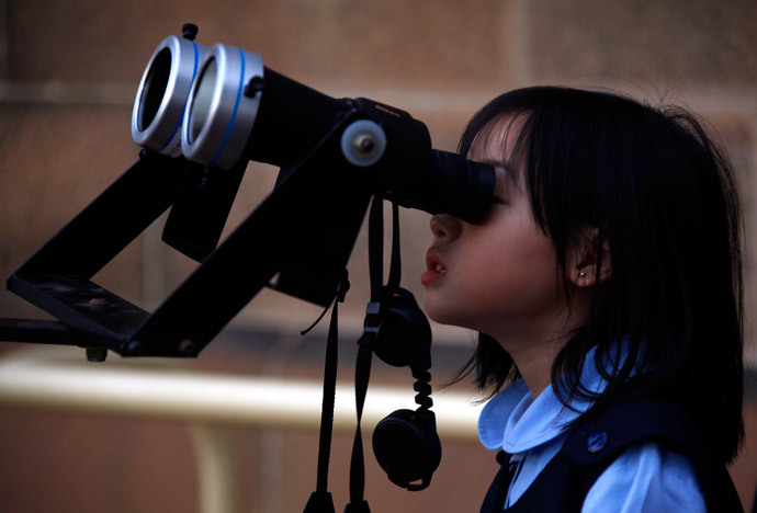 A girl looks through a telescope to try and see a partial solar eclipse from Sydney's Observatory Hill April 29, 2014. (Reuters / David Gray)