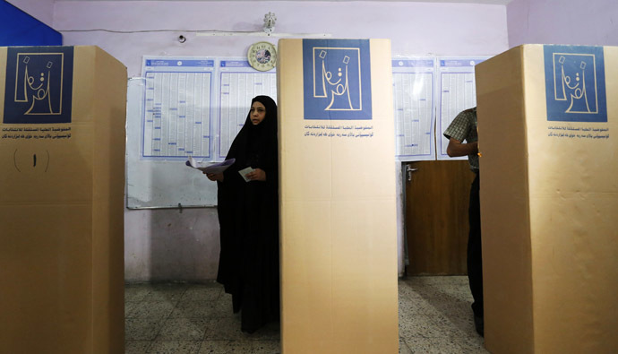 Resident mark their ballots at voting booths at a polling station during parliamentary election in Baghdad April 30, 2014. (Reuters/Thaier Al-Sudani)