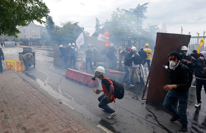 Protesters shield themselves from tear gas fired by riot police during a May Day demonstration in Istanbul May 1, 2014 (Reuters / Umit Bektas)