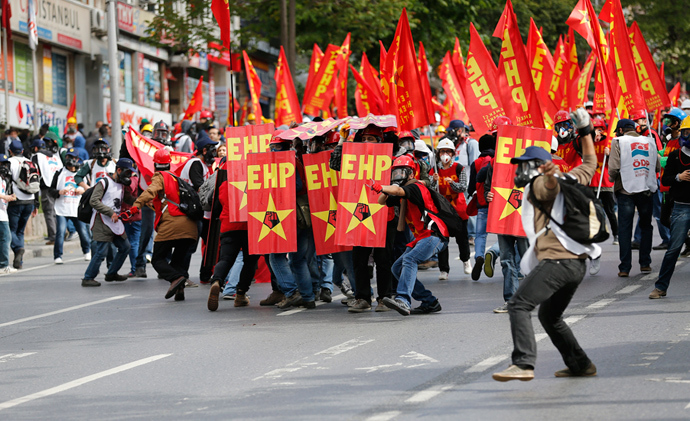 A protester (C) takes aim at riot police with a slingshot during a May Day demonstration in Istanbul May 1, 2014 (Reuters / Murad Sezer)