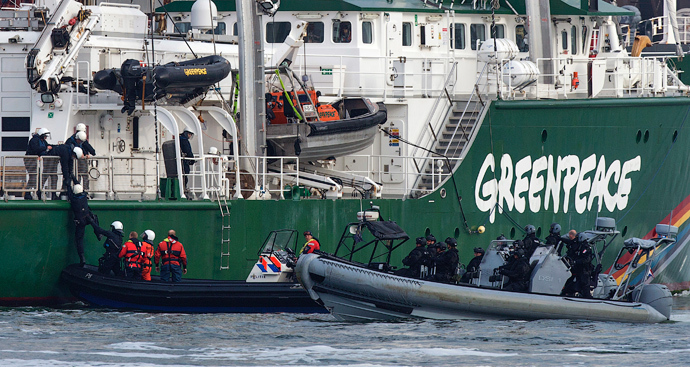 Dutch police climb onboard the Greenpeace ship, the Rainbow Warrior, after members of Greenpeace draped banners saying "No Arctic Oil" from the Russian oil tanker Mikhail Ulyanov, in the harbour of Rotterdam May 1, 2014 (Reuters / Michael Kooren)
