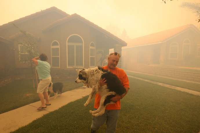 People evacuate from their homes as a wildfire driven by fierce Santa Ana winds closes in on them in Rancho Cucamonga, California, April 30, 2014 (Reuters / David McNew)