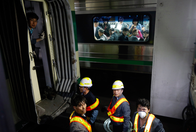 Passengers on the opposite side look at a damaged subway train as workers check it at a subway station in Seoul May 2, 2014 (Reuters / Kim Hong-Ji)