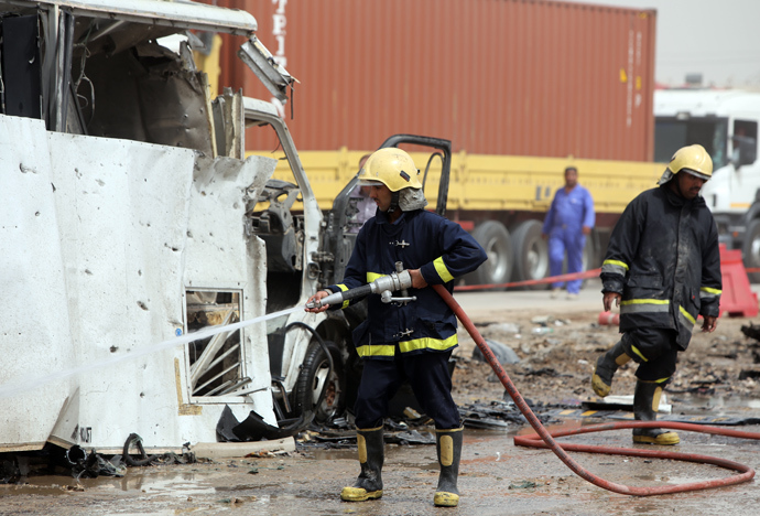 Iraqi fire fighters douse the site of a car bomb explosion at a checkpoint in the Suweirah area, 45 kms south of Baghdad, on April 21, 2014 (AFP Photo)