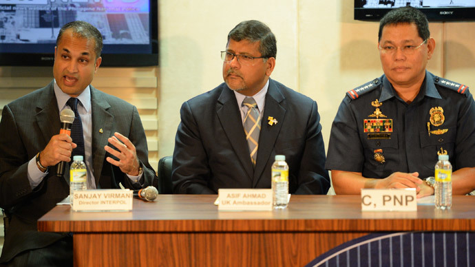 Sanjay Virmani (L), director of Interpol's Digital Crime Centre, gestures as he speaks while Britain's Ambassador to the Philippines Asif ahmad (C) and Philippine police chief Alan Purisima (R) listen during a press conference at the police headquarters in Manila on May 2, 2014. (AFP Photo / Ted Aljibe)