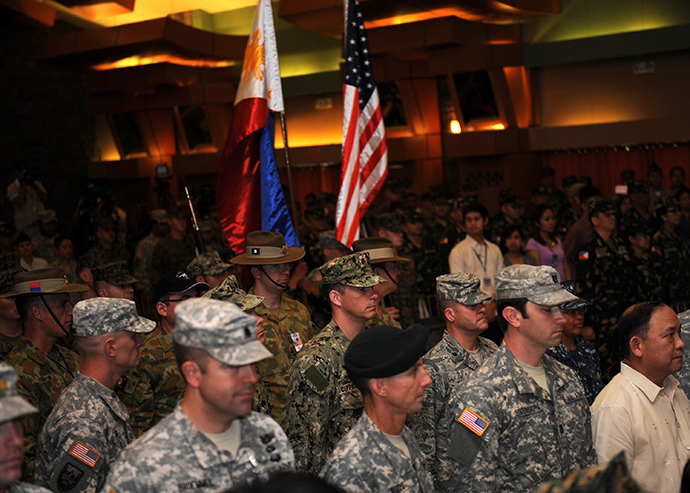 Philippine (R) and US soldiers (L) stand at attention while their national flags are carried to the stage for the opening ceremony of the Philippine-US annual joint military exercises or locally known as "Balikatan 2014", at the military headquarters in Manila on May 5, 2014 (AFP Photo / Ted Aljibe)