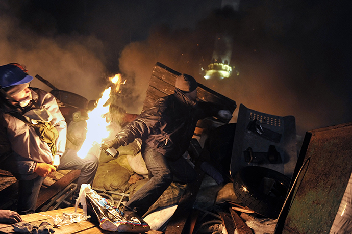 A protester hurls a molotov cocktail towards police from the barricades at Independence square in Kiev on February 19, 2014 (AFP Photo / Louisa Gouliamaki)
