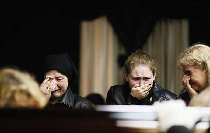 Mourners grieve at the coffin of Vyacheslav Markin, a regional parliament deputy who died in a fire at the trade union building on Friday, at his funeral in Odessa May 5, 2014. (Reuters / Gleb Garanich)