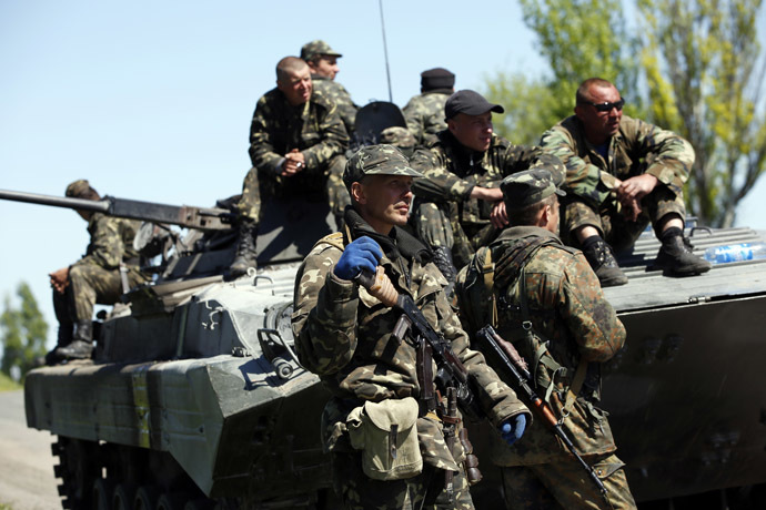 Armed men in Ukrainian military uniforms stand guard beside an armoured personnel carrier at a checkpoint in Mariupol, eastern Ukraine May 7, 2014. (Reuters/Marko Djuric)